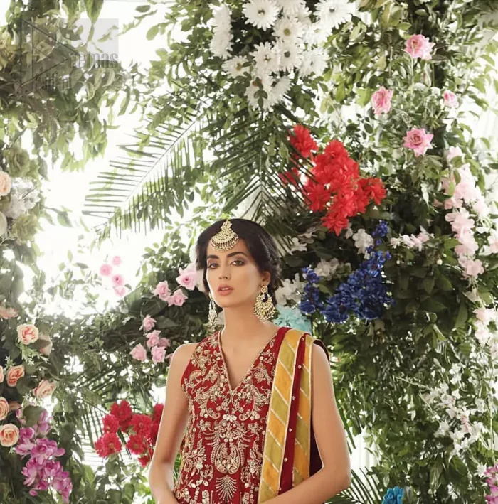 Tradition meets modernity. Boost your confidence and style in this glamorous attire accentuated with finest zardozi work embroidery and scalloped borders with dandling pearls. This maroon sleeveless shirt is ornamented with golden and light golden zardozi work. The scalloped hemline is decorated with dangling pearls. Style it confidently with maroon sharara adorned with beautiful gota work. It is paired with an ethereal maroon dupatta with scattered sequins all over and four sided applique borders.