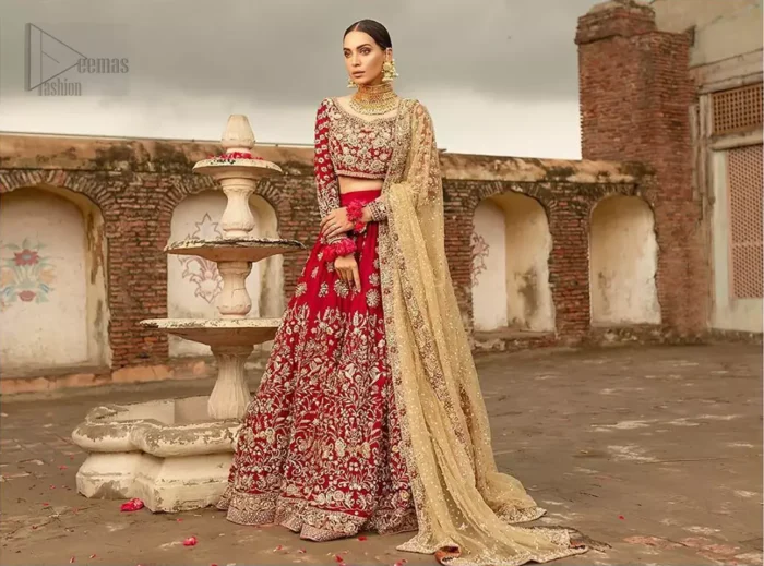 Our deep red bridal dress will make your special day even more perfect. Infused with classical glamour. Strike a breathtakingly elegant pose in this wedding dress. This artisan piece includes intricate hand embellishment. This highly skilled technique involves hand needle work to add beads and sequins to the fabric, giving your garments a unique look. The embroidery is done in the shades of light golden, antique and maroon thread work. The blouse is fully embellished and lehenga is adorned with floral details all over and thick embellished bottom. Furthermore the lehenga is also intensified with sprinkled floral motifs. Complete the look with golden net dupatta enhanced with sprinkled sequins on the ground and four sided embellished border.