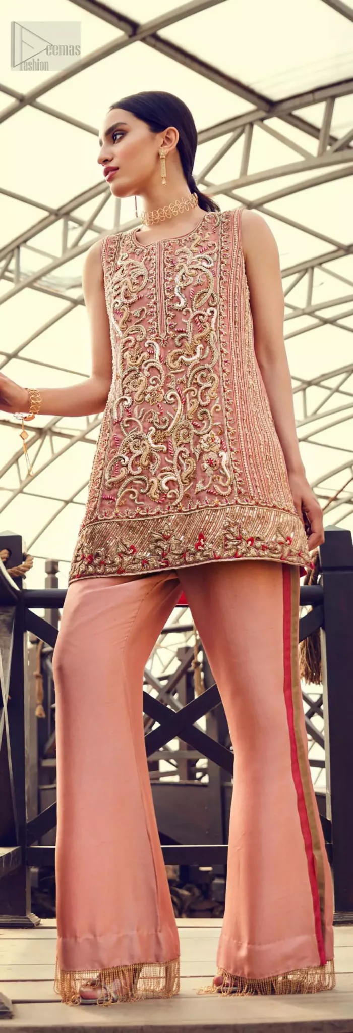Delicately crafted and personifying chic elegance with an element of grandiose. You are all set to make a lasting impact with the divine royalty of this dress. The outfit is perfected with loaded dull golden, golden and antique work. The shirt is delicately hand crafted using the finest old age techniques and materials including kora, dabka, tilla, sequins and pearls. The back of the shirt is highlighted with cutwork embellishment. Furthermore it is also enhanced with thread embroidery. This outfit is comprises with peach raw silk bell bottom. Complete the look with peach organza dupatta decorated with sequins spray all over.