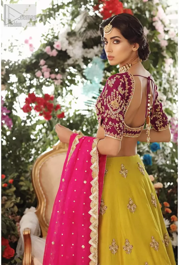 Adorn yourself with this breath-taking mehndi lehenga outfit. This beautiful mehndi dress comes with yellow lehenga with scattered beautiful embellished motifs and floral booties around a large central motif and it finished with frilled border. It is coordinated with a beautiful plum blouse adorned with zardozi work in the shades of golden and silver. Style it up with pink organza dupatta with sequins sprayed all over it along with gota finishing on all four sides.