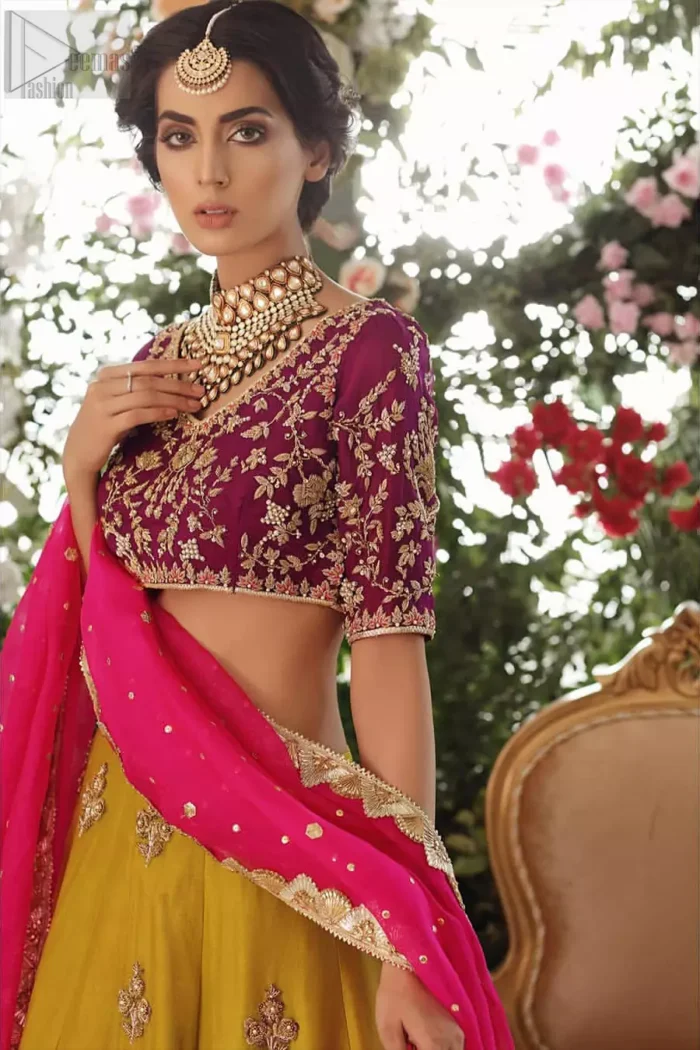 Adorn yourself with this breath-taking mehndi lehenga outfit. This beautiful mehndi dress comes with yellow lehenga with scattered beautiful embellished motifs and floral booties around a large central motif and it finished with frilled border. It is coordinated with a beautiful plum blouse adorned with zardozi work in the shades of golden and silver. Style it up with pink organza dupatta with sequins sprayed all over it along with gota finishing on all four sides.