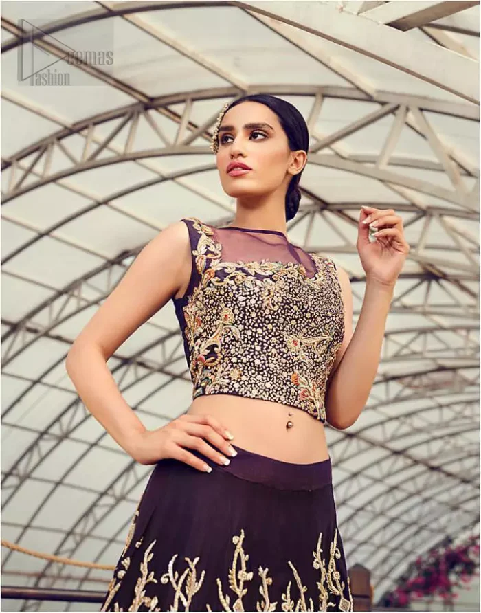 Captured in traditional silhouette, The bridal stands out due to its uniqueness and the perfect fusion of modern cut and traditional embroidery. This dress is beautifully decorated with heavy embroidery. It is highlighted with light golden kora, dabka, tilla, sequins and pearls. Blouse is fully enhanced with zardosi work and multiple color embroidery. It comes with full embellished lehenga adorned with floral booties and heavy embellished bottom. It is coordinated with plum organza dupatta which is sprinkled with sequins all over it.