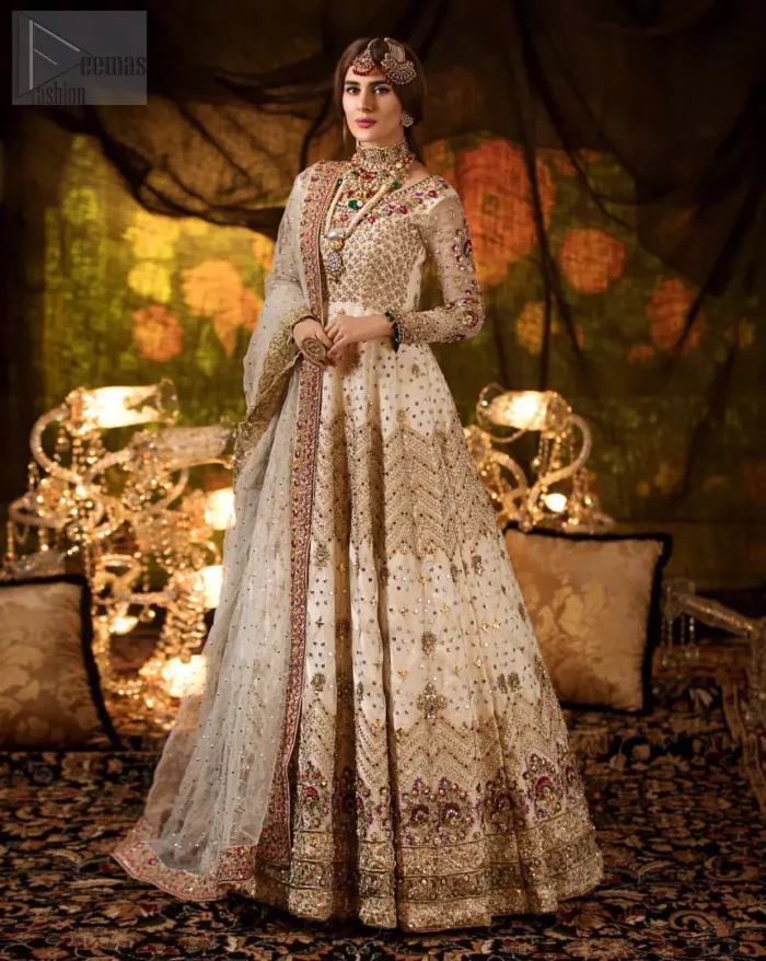 Delicately crafted and personifying chic elegance with an element of grandiose. This outfit is beautifully sculptured with geometric embroidery, adorned with heavy embellished bottom with golden and antique shaded kora, dabka, pearl and sequins work all over. Furthermore the outfit is emphasized with colorful thread work and mukesh embroidery. It is coordinated with ivory dupatta with sequins sprayed all over it along with zardozi work all around the edges to make the look complete.