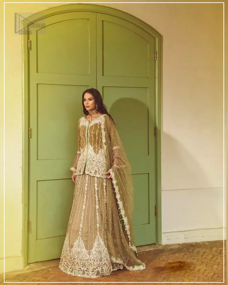 Let the crowd stare and make it worth their while when you walk wearing this outfit. Designed to flaunt your best features, the front open shirt carries intricate embellishment on the hemline and neckline. Complete the look with artfully coordinated lehenga which is ornamented with a bold and captivating design with a traditional intricate embroidery. Furthermore the lehenga and shirt is also emphasized with silver embroidered vertical lines. The fawn net dupatta with chann and scalloped finishing all around the edges makes the look complete. Upholding the idea of simple is beautiful, you would definitely want to wear this for your next occasion.