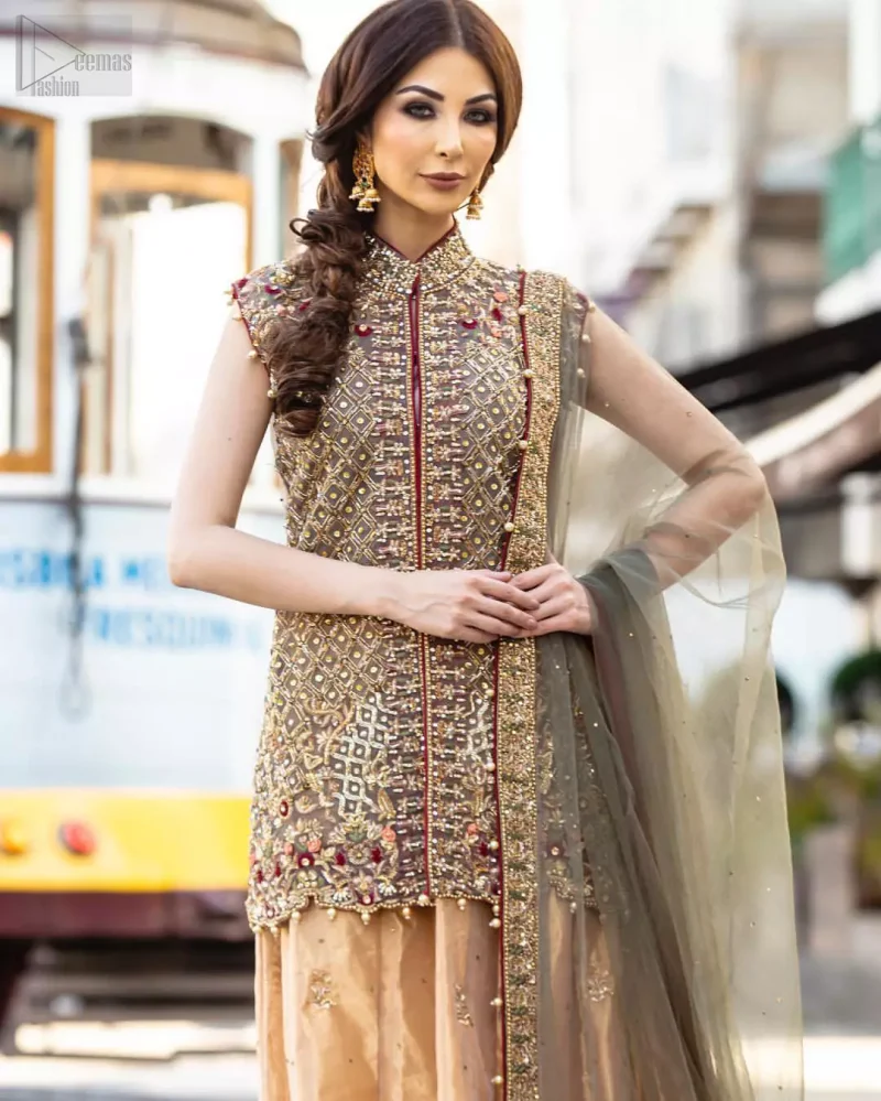 Our selection of wedding dresses offers simple evening glamour dresses. Add a taupe gray color to your wardrobe with our modern styled front open shirt enhanced with embellished geometric patterns. The neckline is beautifully designed with collar neck and scalloped hemline is emphasized with dangling pearls and multiple color embroidery. It is paired with taupe gray dupatta with one sided hand embellished border and sprinkled sequins all over. Compliment the look with fawn lehenga adorned with floral bunches. The combination of fawn and taupe gray is absolutely breathetaking.