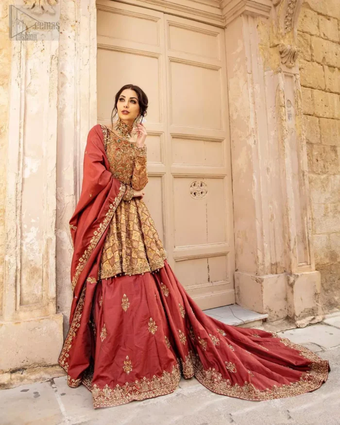 Chic and sophisticated perfectly describe this simply stunning wedding dress. This artisan piece includes intricate hand embellishment. This technique gives our garments a unique look, and helps to sustain a traditional craft carried out by skilled artisans across Asia. The short frock is fully embellished with zardozi work in the shades of golden and silver on tea rose canvas. Finished with dangling pearls on hemline. Compliment the look with coral back train lehenga exaggerated with embellished bottom and sprinkled floral bunches. The coral raw silk dupatta is emphasized with intricate embroidered borders.