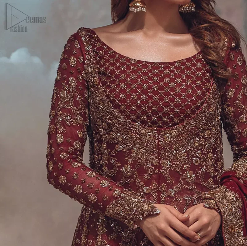 This wedding season, create a blissful aura with the treasure of love and elegance. An artistic vision of classic style and luxurious detailing, transpire into a truly romantic and iconic bridal for your big day. The front open floor length maxi is adorned with unique geometric patterns around the neckline and rest of the maxi is ornamented with floral embroidery. The kora, dabka, tilla and pearls embroidery is done in the shade of tan. Compliment the look with wide flared lehenga. The combination ofgolden with maroon is absolutely breathetaking. The dupatta incorporates beautifully designed borders on all four sides and sprinkled sequins to give it a perfect maharani look.