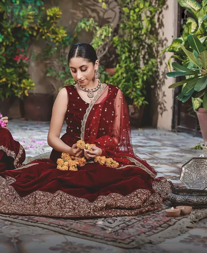 Let the crowd stare and make it worth their while when you walk wearing this maroon velvet lehenga blouse. Designed to flaunt your best features, the sleeveless blouse carries sequins spray with round neckline. Upholding the idea of simple is beautiful, you would definitely want to wear this for your next occasion or on your big day. The blouse is paired with maroon lehenga with hand embellishments on velvet base. The wide flare lehenga hemline is emphasized with intricate details with antique shaded kora, dabka, tilla and sequins work that gives the perfect ending t this outfit. Paired with maroon net dupatta having lace on all four sides.