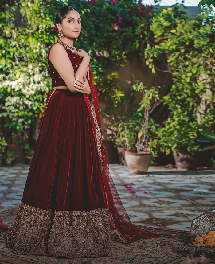 Let the crowd stare and make it worth their while when you walk wearing this maroon velvet lehenga blouse. Designed to flaunt your best features, the sleeveless blouse carries sequins spray with round neckline. Upholding the idea of simple is beautiful, you would definitely want to wear this for your next occasion or on your big day. The blouse is paired with maroon lehenga with hand embellishments on velvet base. The wide flare lehenga hemline is emphasized with intricate details with antique shaded kora, dabka, tilla and sequins work that gives the perfect ending t this outfit. Paired with maroon net dupatta having lace on all four sides.