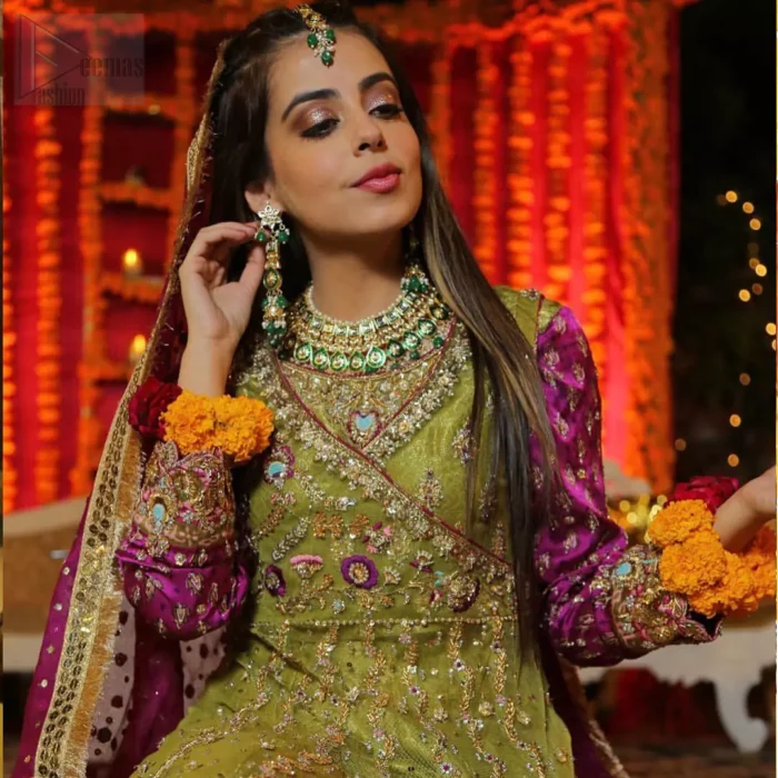 Nothing speaks of femininity and class louder than this mehndi outfits for bridesmaids. The sequinned whimsical florals embroidered across the flattering bodice in this ethereal frock is sure to turn heads in every room you walk into. The pairing of champagne zardozi work with parrot green fabric is an artist’s dream colour palette. The frock hemline is emphasized with banarsi applique details that gives perfect ending to this outfit. It comprises with matching tissue lehenga. The magenta organza dupatta with chann and gota work, finishing with kiran lace all around the edges makes the look complete. 
