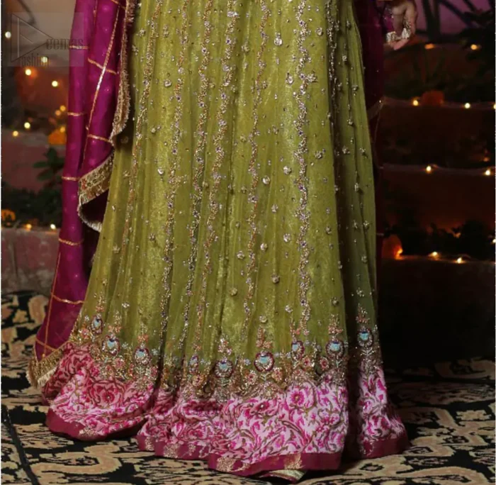Nothing speaks of femininity and class louder than this mehndi outfits for bridesmaids. The sequinned whimsical florals embroidered across the flattering bodice in this ethereal frock is sure to turn heads in every room you walk into. The pairing of champagne zardozi work with parrot green fabric is an artist’s dream colour palette. The frock hemline is emphasized with banarsi applique details that gives perfect ending to this outfit. It comprises with matching tissue lehenga. The magenta organza dupatta with chann and gota work, finishing with kiran lace all around the edges makes the look complete. 