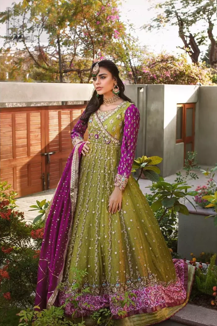 Nothing speaks of femininity and class louder than this mehndi outfits for bridesmaids. The sequinned whimsical florals embroidered across the flattering bodice in this ethereal frock is sure to turn heads in every room you walk into. The pairing of champagne zardozi work with parrot green fabric is an artist’s dream colour palette. The frock hemline is emphasized with banarsi applique details that gives perfect ending to this outfit. It comprises with matching tissue lehenga. The magenta organza dupatta with chann and gota work, finishing with kiran lace all around the edges makes the look complete. 