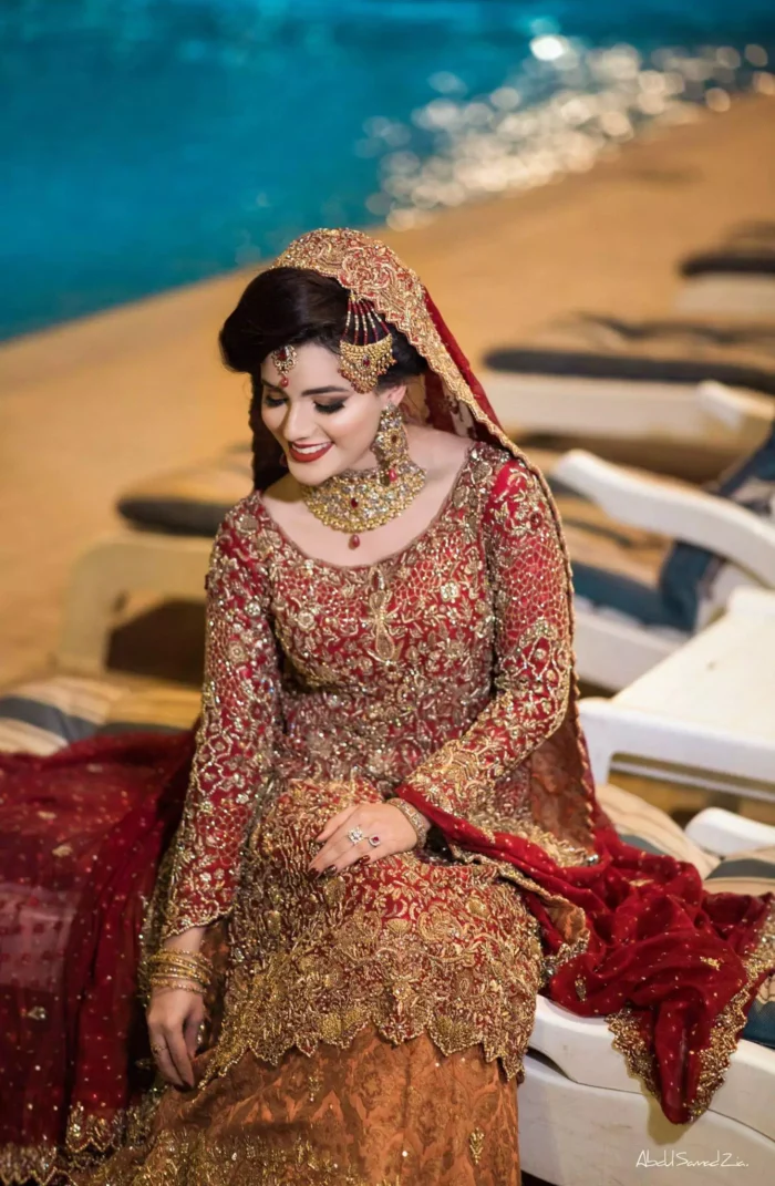 Pakistani Reception Wear - Maroon Shirt – Rust and Maroon Lehenga. You are all set to make a lasting impact with the divine royalty of this dress. This ravishing ensemble is sure to make you look like glamorous royalty with immaculate work covering every inch of the shirt. It boasts a pretty scallop hemline and full sleeves with zardozi embellishment. Compliment the look with flared lehenga. The combination of rust with maroon is absolutely breathtaking. Elegance is personified when it gets paired up with an all-over sequins spray-on dupatta with alternating scalloped borders detailing. This is an ensemble that deserves to be flaunted.