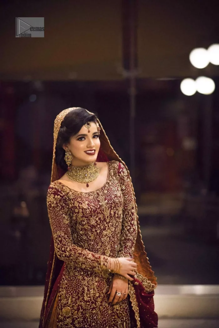 Pakistani Reception Wear - Maroon Shirt – Rust and Maroon Lehenga. You are all set to make a lasting impact with the divine royalty of this dress. This ravishing ensemble is sure to make you look like glamorous royalty with immaculate work covering every inch of the shirt. It boasts a pretty scallop hemline and full sleeves with zardozi embellishment. Compliment the look with flared lehenga. The combination of rust with maroon is absolutely breathtaking. Elegance is personified when it gets paired up with an all-over sequins spray-on dupatta with alternating scalloped borders detailing. This is an ensemble that deserves to be flaunted.