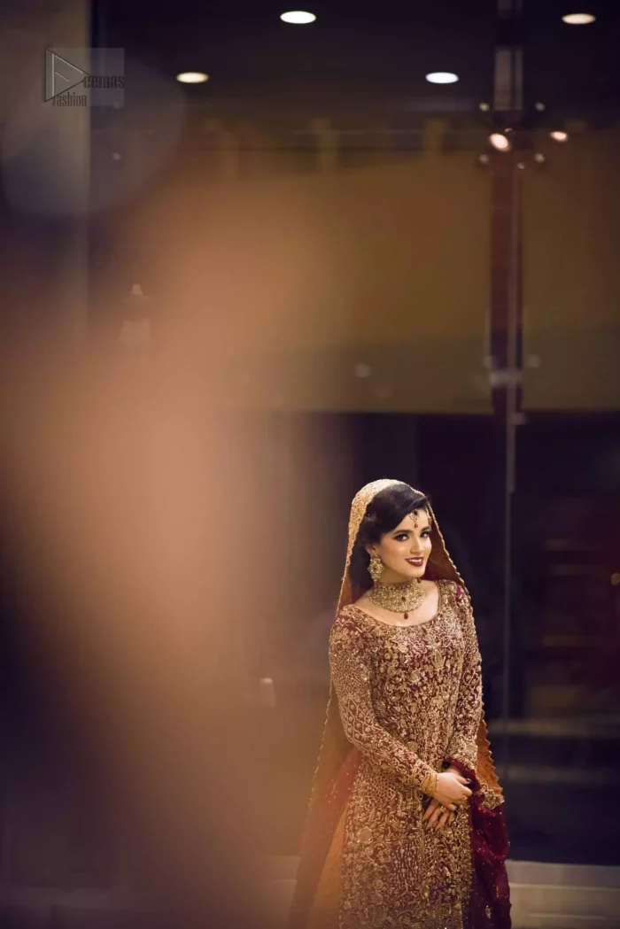 Pakistani Reception Wear - Maroon Shirt – Rust and Maroon Lehenga. You are all set to make a lasting impact with the divine royalty of this dress. This ravishing ensemble is sure to make you look like glamorous royalty with immaculate work covering every inch of the shirt. It boasts a pretty scallop hemline and full sleeves with zardozi embellishment. Compliment the look with flared lehenga. The combination of rust with maroon is absolutely breathtaking. Elegance is personified when it gets paired up with an all-over sequins spray-on dupatta with alternating scalloped borders detailing. This is an ensemble that deserves to be flaunted.