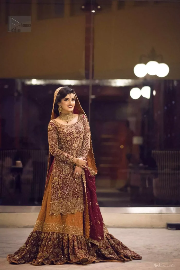 Pakistani Reception Wear - Maroon Shirt – Rust and Maroon Lehenga. You are all set to make a lasting impact with the divine royalty of this dress. This ravishing ensemble is sure to make you look like glamorous royalty with immaculate work covering every inch of the shirt. It boasts a pretty scallop hemline and full sleeves with zardozi embellishment. Compliment the look with flared lehenga. The combination of rust with maroon is absolutely breathtaking. Elegance is personified when it gets paired up with an all-over sequins spray-on dupatta with alternating scalloped borders detailing. This is an ensemble that deserves to be flaunted.