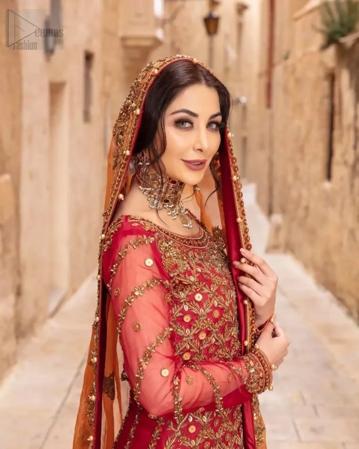 Make your big day more beautiful with our excessively embroidered back train lehenga shirt featuring delicately embellished neckline along with geometric patterns highlighted in antique shaded embroidery detailing and intricately embroidered borders that gives perfect ending to this outfit. Pair it up with a breathtaking back train lehenga with scattered motifs on the ground and embellished hemline. The orange organza dupatta with floral motifs and finishing all around the edges makes the look complete. The combination of orange with red is absolutely breathetaking.