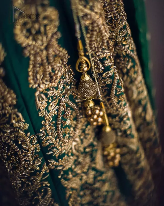 This artisanal piece is rendered in grace and timelessness. This outfit makes a statement in this stunningly floraison, perfect blend of glamour and tradition with outstanding craftsmanship and gorgeous detailing. This mehndi dress in a dreamy shade of green, enhanced with hand embellishments on neckline and sleeves. The wide flared lehenga is an example of remarkable handiwork with a lot of attention to detail. The sculptured embroidery is in the shade of golden. Complete the look with bottle green organza dupatta emphasized with tiny floral motifs on the ground and four sided embellished border.