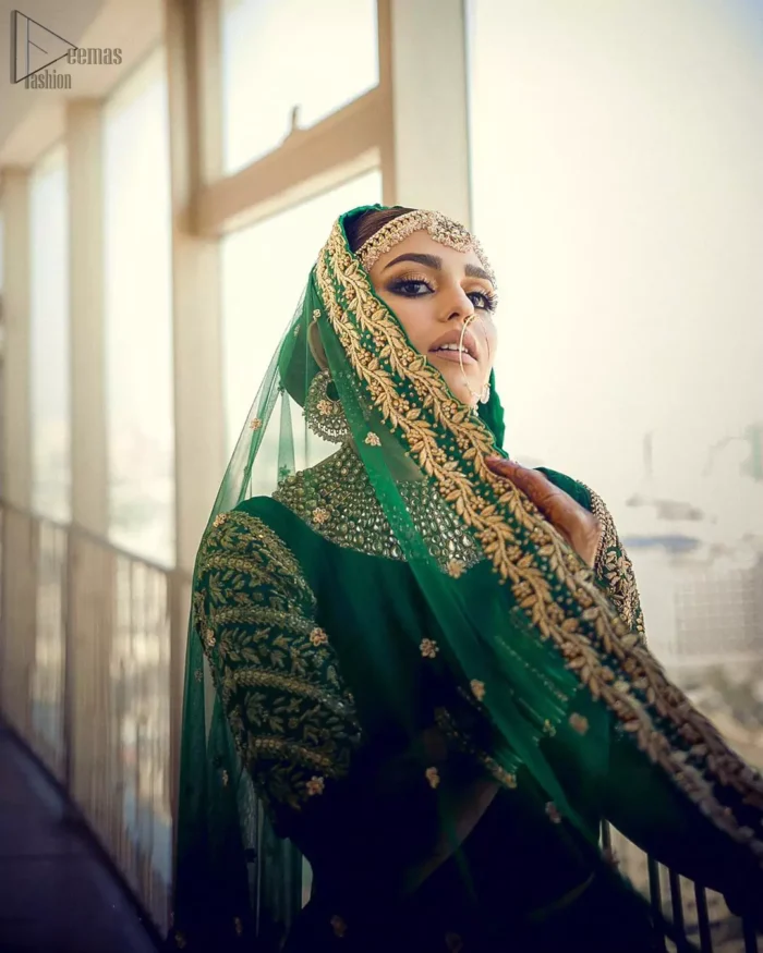 This artisanal piece is rendered in grace and timelessness. This outfit makes a statement in this stunningly floraison, perfect blend of glamour and tradition with outstanding craftsmanship and gorgeous detailing. This mehndi dress in a dreamy shade of green, enhanced with hand embellishments on neckline and sleeves. The wide flared lehenga is an example of remarkable handiwork with a lot of attention to detail. The sculptured embroidery is in the shade of golden. Complete the look with bottle green organza dupatta emphasized with tiny floral motifs on the ground and four sided embellished border.