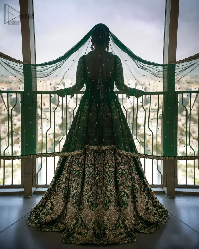 This artisanal piece is rendered in grace and timelessness. This outfit makes a statement in this stunningly floraison, perfect blend of glamour and tradition with outstanding craftsmanship and gorgeous detailing. This mehndi dress in a dreamy shade of green, enhanced with hand embellishments on neckline and sleeves. The wide flared lehenga is an example of remarkable handiwork with a lot of attention to detail. The sculptured embroidery is in the shade of golden. Complete the look with bottle green organza dupatta emphasized with tiny floral motifs on the ground and four sided embellished border.
