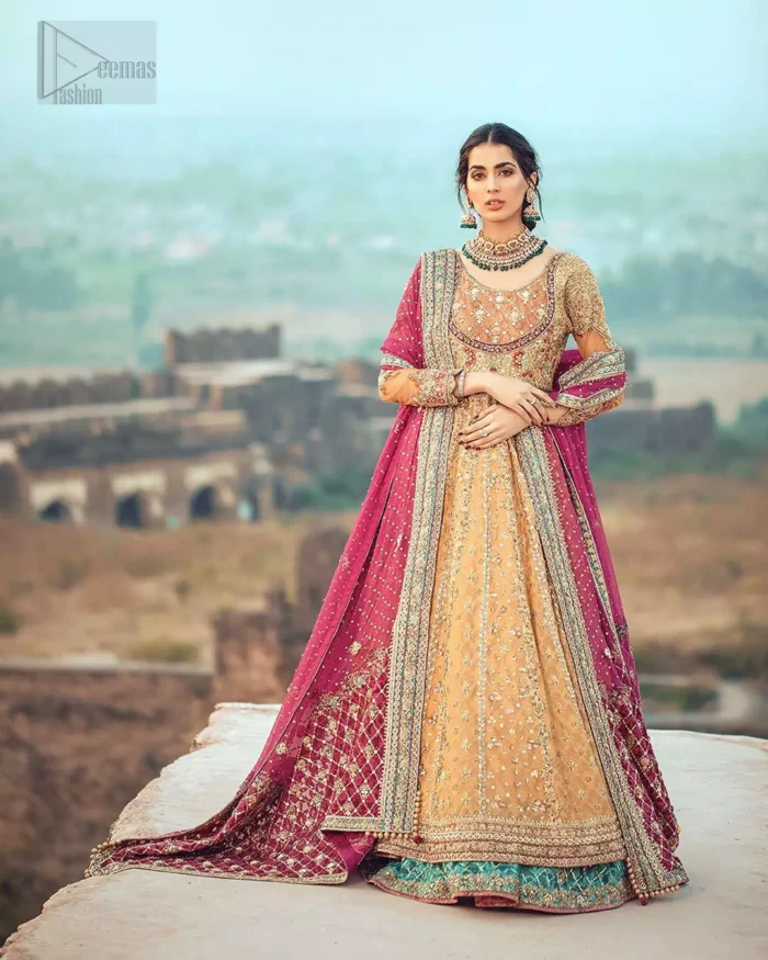 This exceptionally detailed anarkali frock is cut in a seductive fit and flare silhouette that’s sure to turn heads. The bodice with round neckline is adorned in richly beaded work with fabulous sparkle and zardozi work. Furthermore the panels of the shirt is vertically adorned with golden kora, dabka, tilla work and various flora motifs meticulously using on the ground. The frock is comprises with ferozi lehenga emphasized with criss cross patterns done with golden embellishment. Elegance is personified when it gets paired up with an embroidered dupatta with alternating motifs and sequins detailing.