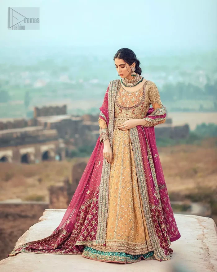 This exceptionally detailed anarkali frock is cut in a seductive fit and flare silhouette that’s sure to turn heads. The bodice with round neckline is adorned in richly beaded work with fabulous sparkle and zardozi work. Furthermore the panels of the shirt is vertically adorned with golden kora, dabka, tilla work and various flora motifs meticulously using on the ground. The frock is comprises with ferozi lehenga emphasized with criss cross patterns done with golden embellishment. Elegance is personified when it gets paired up with an embroidered dupatta with alternating motifs and sequins detailing.