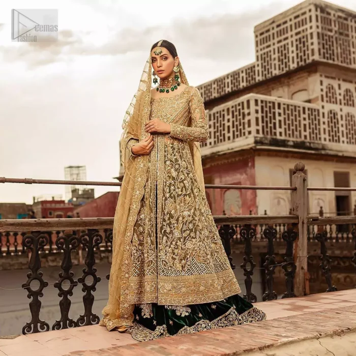 The new season is all about making a statement. Make your moment memorable being a queen in our fawn front open pishwas intensified with voguish sleeves, floral pattern all over and finished with thick embroidered border. The back of the shirt is also enhanced with criss cross patterns filling with beads. Pair it up with bottle green velvet lehenga emphasized with scattered floral motifs and intricate zardozi detailing at the bottom. Dupatta is decorated with vintage froral and finished with embroidered scalloped border on four sides which makes this outfit more beautiful.