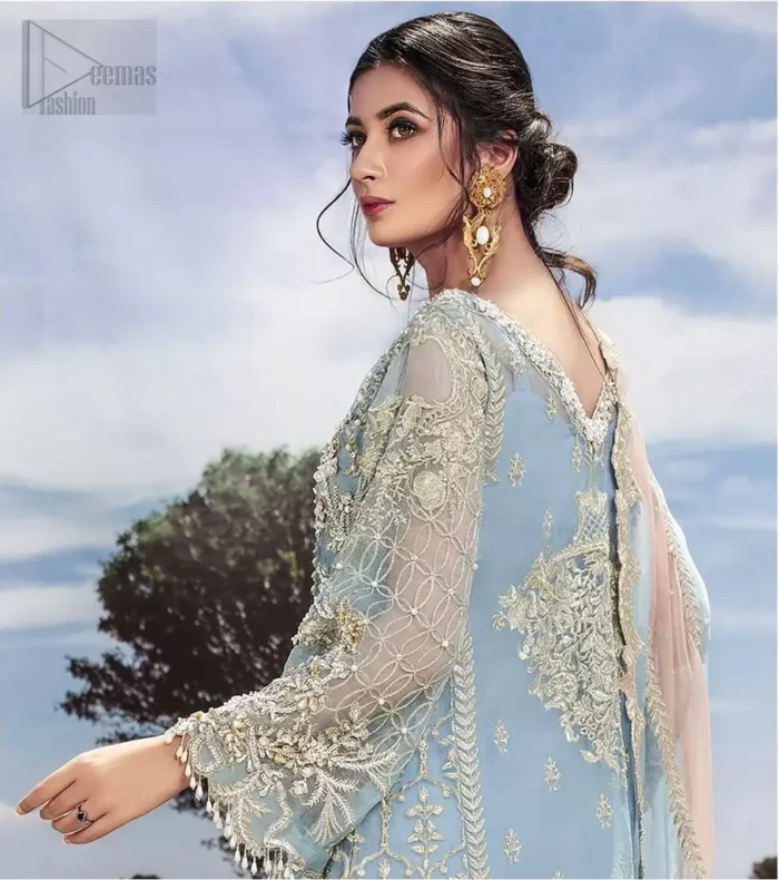 Intricate details, flamboyant silhouettes and mastery of colour are what makes this dress stand out from the rest. This is one of the elegant pieces are sure to stay in your heart and your wardrobe forever. The front of the shirt is beautifully ornamented with floral motifs and bootis, also a delicate arrangement of geometric patterns on the hemline with light golden and silver zardozi work. The back of the shirt is accentuated with a large central motif and scattered tiny floral motifs all over. It comprises with ferozi capri pants emphasized with bottom. To complete the look, go with a gradient dupatta having geometric patterns on pallu and scalloped border along the length. Furthermore the outfit is fully decorated with scalloped finishing and tassels.