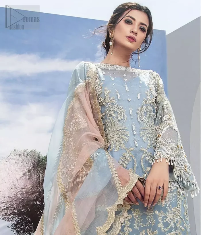Intricate details, flamboyant silhouettes and mastery of colour are what makes this dress stand out from the rest. This is one of the elegant pieces are sure to stay in your heart and your wardrobe forever. The front of the shirt is beautifully ornamented with floral motifs and bootis, also a delicate arrangement of geometric patterns on the hemline with light golden and silver zardozi work. The back of the shirt is accentuated with a large central motif and scattered tiny floral motifs all over. It comprises with ferozi capri pants emphasized with bottom. To complete the look, go with a gradient dupatta having geometric patterns on pallu and scalloped border along the length. Furthermore the outfit is fully decorated with scalloped finishing and tassels.