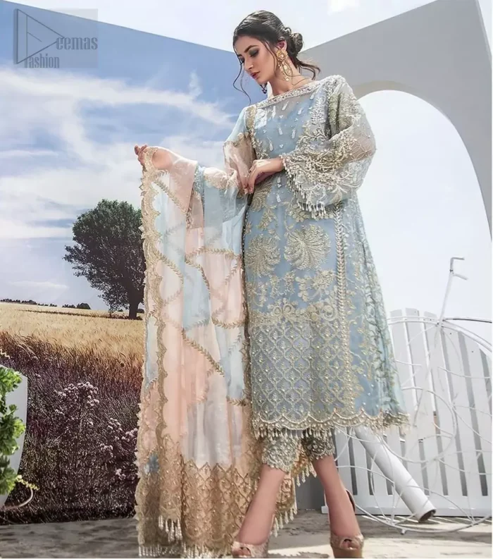 Intricate details, flamboyant silhouettes and mastery of colour are what makes this dress stand out from the rest. This is one of the elegant pieces are sure to stay in your heart and your wardrobe forever. The front of the shirt is beautifully ornamented with floral motifs and bootis, also a delicate arrangement of geometric patterns on the hemline with light golden and silver zardozi work. The back of the shirt is accentuated with a large central motif and scattered tiny floral motifs all over. It comprises with ferozi capri pants emphasized with bottom. To complete the look, go with a gradient dupatta having geometric patterns on pallu and scalloped border along the length. Furthermore the outfit is fully decorated with scalloped finishing and tassels.
