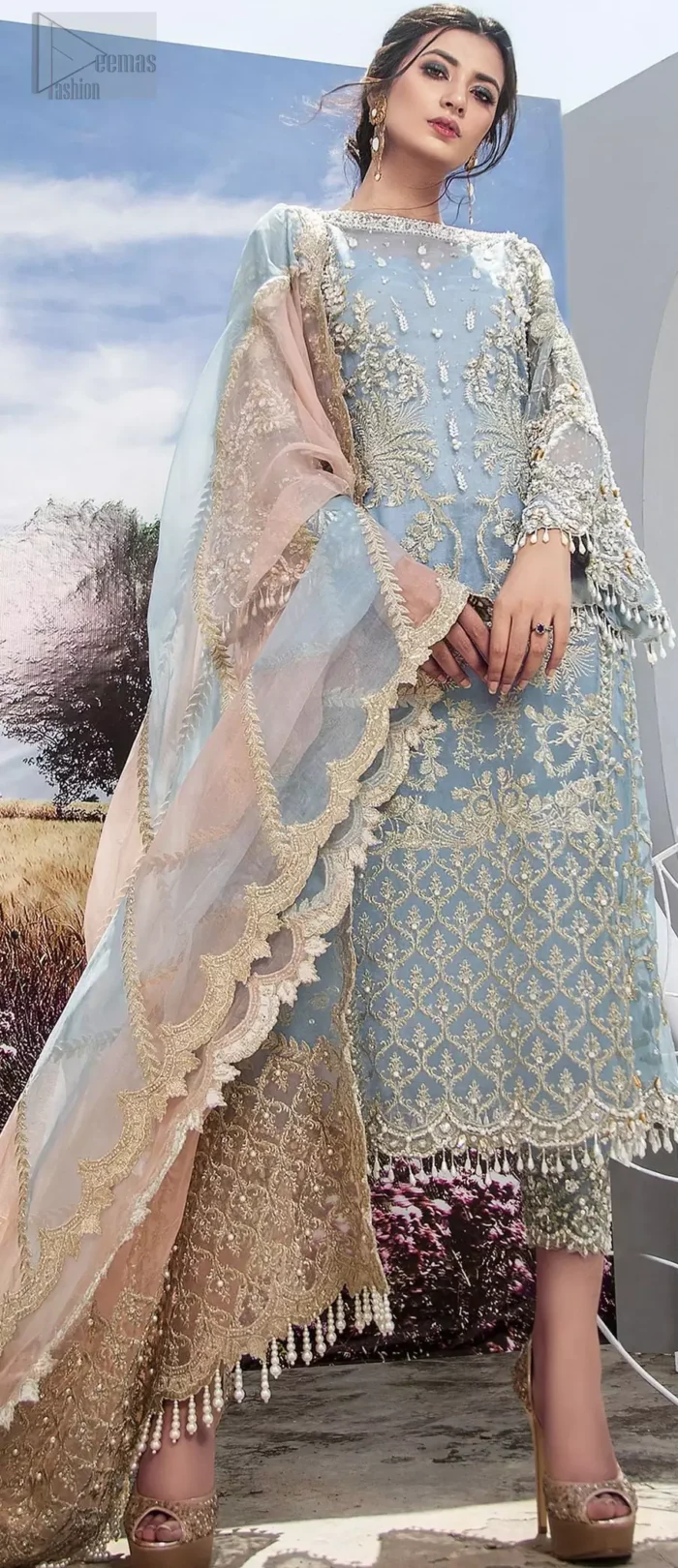 Intricate details, flamboyant silhouettes and mastery of colour are what makes this dress stand out from the rest. This is one of the elegant pieces are sure to stay in your heart and your wardrobe forever. The front of the shirt is beautifully ornamented with floral motifs and bootis, also a delicate arrangement of geometric patterns on the hemline with light golden and silver zardozi work. The back of the shirt is accentuated with a large central motif and scattered tiny floral motifs all over. It comprises with ferozi capri pants emphasized with bottom. To complete the look, go with a gradient dupatta having geometric patterns on pallu and scalloped border along the length. Furthermore the outfit is fully decorated with scalloped finishing and tassels.