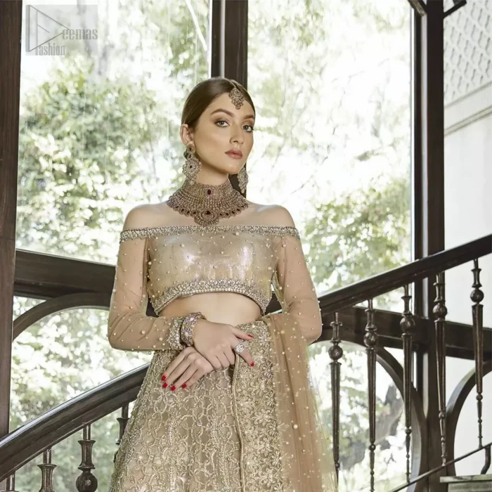 This outfit brings drama and playfulness to traditional lehenga blouse with a modern approach. Classic balanced pattern on the lehenga of tissue fabric adds exquisiteness to the look. The selection of color much of a choice for the festive season. The off shoulder blouse make a statement with light golden zardozi work. Complete the look with golden dupatta heavily embellished from all four sides and sprinkled with sequins all over.