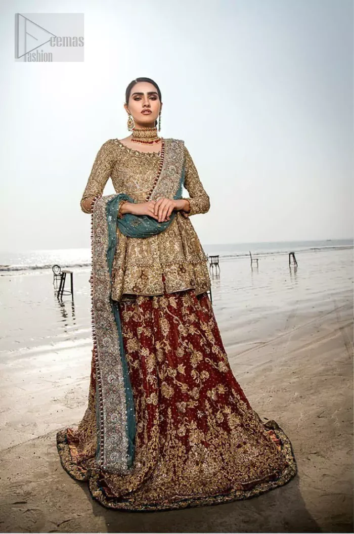 This wedding season, create a blissful aura with the treasure of love and elegance. An artistic vision of classic style and luxurious detailing infused with a bohemian spirit, transpire into a truly romantic and iconic bridal for your big day. The golden double layered peplum is heavily laden with zardozi and the perfect blend of traditional flamboyance and modern elegance in design. Pair it up with maroon lehenga enhanced with golden zardozi work. To complete the look, go with teel dupatta scattered with sequins all over the ground and heavily embellished borders to give it a perfect maharani look.