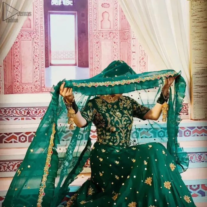 Nothing speaks of femininity and class louder than this green mehndi outfits for bridesmaids. This beautiful outfit comes with a green lehenga which is beautifully embellished with motifs, sprinkled with sequins and it finished with a thick embellished border. The blouse is breathtakingly ornamented with floral bootis which covers every inch of the blouse. The dupatta incorporates beautifully designed scalloped borders and frilled on all four sides. The kora, dabka, tilla, sequins and pearls work are done in the shades of golden.