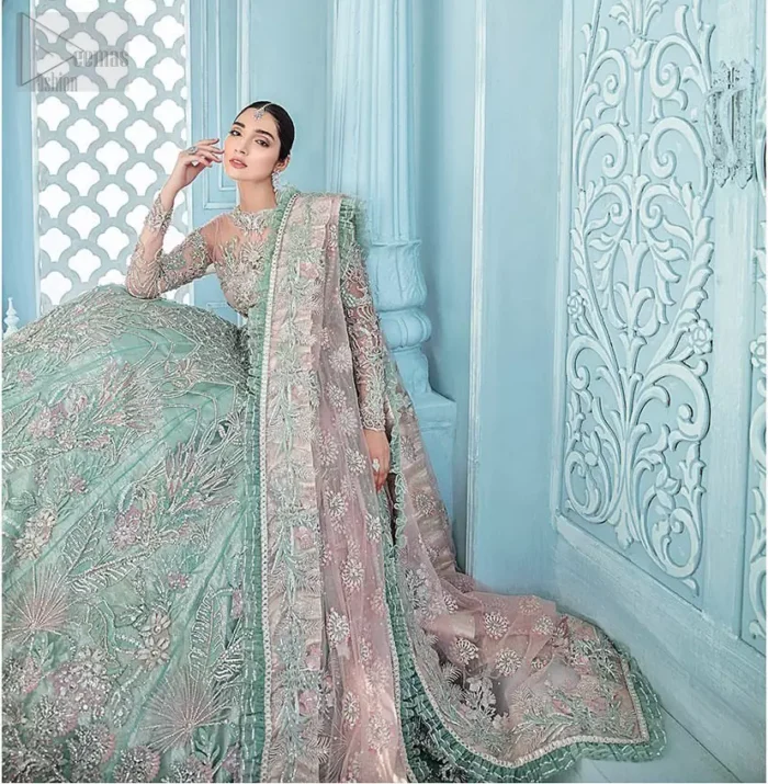 A enchanting amalgamation. This fairytale ensemble is everything that you need to impress everyone. The fusion of rich fabrics intricately designed with floral powdery hue. Precious uncut stones are threaded together with silver zardozi on pastel color palette to give it an enchantingly exquisite look. The illusion neckline blouse is laden with silver kora, dabka details and pair it up with a beautiful lehenga. The lehenga is adorned with colorful chatta patti waist belt and a captivating geometric jaal finished with scattered floral motifs and scalloped hemline. Finish the look with pink dupatta focusing on heavily embellished borders on all four sides to give it a perfect maharani look.