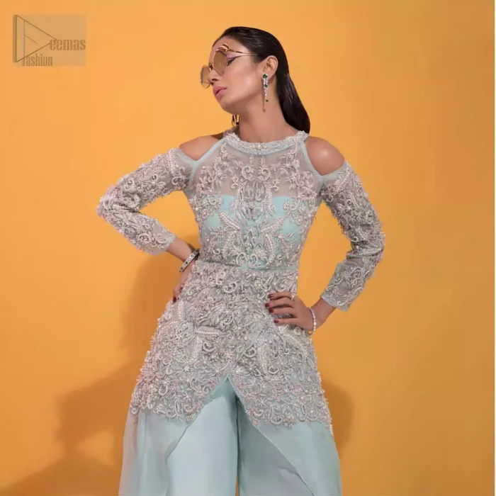 A fashion forward style statement that is contemporary yet chic. This handcrafted remarkable ensemble includes art deco design elements. Unique craftsmanship and detailed embellishments on the pastel green shirt creating delicate yet flamboyant pieces of art in your wardrobe collection. Cold Shoulder sleeves and halter illusion neckline make it more remarkable. To complete the look, go with palazzo pants and organza dupatta sprinkled with sequins all over.