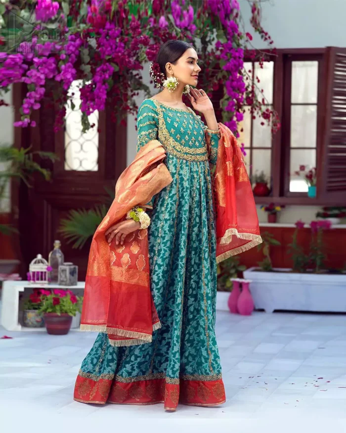 The perfect combination of tradition and class. With a lot of attention to detail, the intricate zardozi work with using glass beading and threads makes the bodice look like nothing but a dream. The tiny floral motifs are also scattered on the bodice. This mehndi outfit is ornamented with vertical embroidered lines and coral applique at the bottom. It comprises with sea green capri pants emphasized with embellished bottom and coral self fabric dupattta. You are all set to make a lasting impact with the divine royalty of this dress.