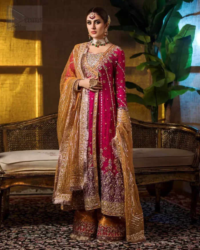 Impeccably on trend. The chic yet elegant front open angrakha style frock is decorated with vertical embroidered lines, embellished neckline and floral bunches. Borders are even more enhanced with rust applique details done with golden and light golden zardozi work. It comes with brocade rust sharara exaggerated with embroidered pink applique on the bottom. Elegance is personified when it gets paired up with rust dupatta decorated with four sided kiran lace and zardozi work on all four sides.