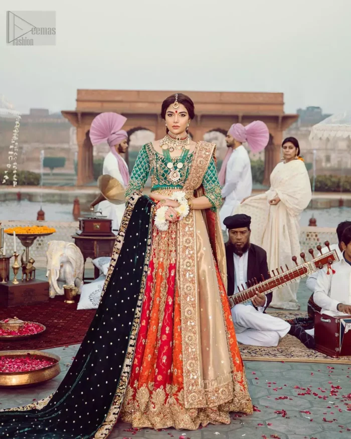 Classic, timeless and truly beautiful, our bridal dress is perfect for your unforgettable day. Excellence of craftsmanship is evident with intricate detailing that features the use of zardozi work. The blouse is beautifully adorned with geometric patterns and floral embroidery with golden zardozi work and finished with dangling beads. Complete the look with artfully coordinated lehenga which is ornamented with a bold and captivating design with a traditional intricate embroidery and scattered tiny floral motifs. The combination of red and orange for lehenga is also captivating. Elegance is personified when it gets paired up with golden dupatta having four sided embroidered border.
