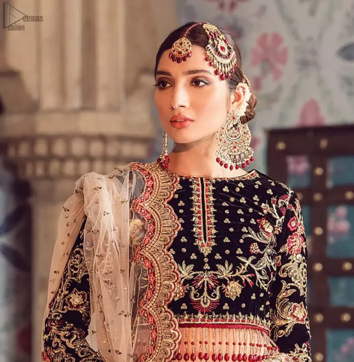 The new season is all about making a statement. Captured in traditional silhouette, The bridal stands out due to its uniqueness and the perfect fusion of modern cut and traditional embroidery. Black velvet blouse is beautifully decorated with multiple colour embroidery and finished with tassels. It comes with full embellished velvet lehenga adorned with applique all around the edges and motifs all over it. This outfit is coordinated with beige net dupatta which is sprinkled with sequins all over it. It is further furnished with a four-sided scalloped border.