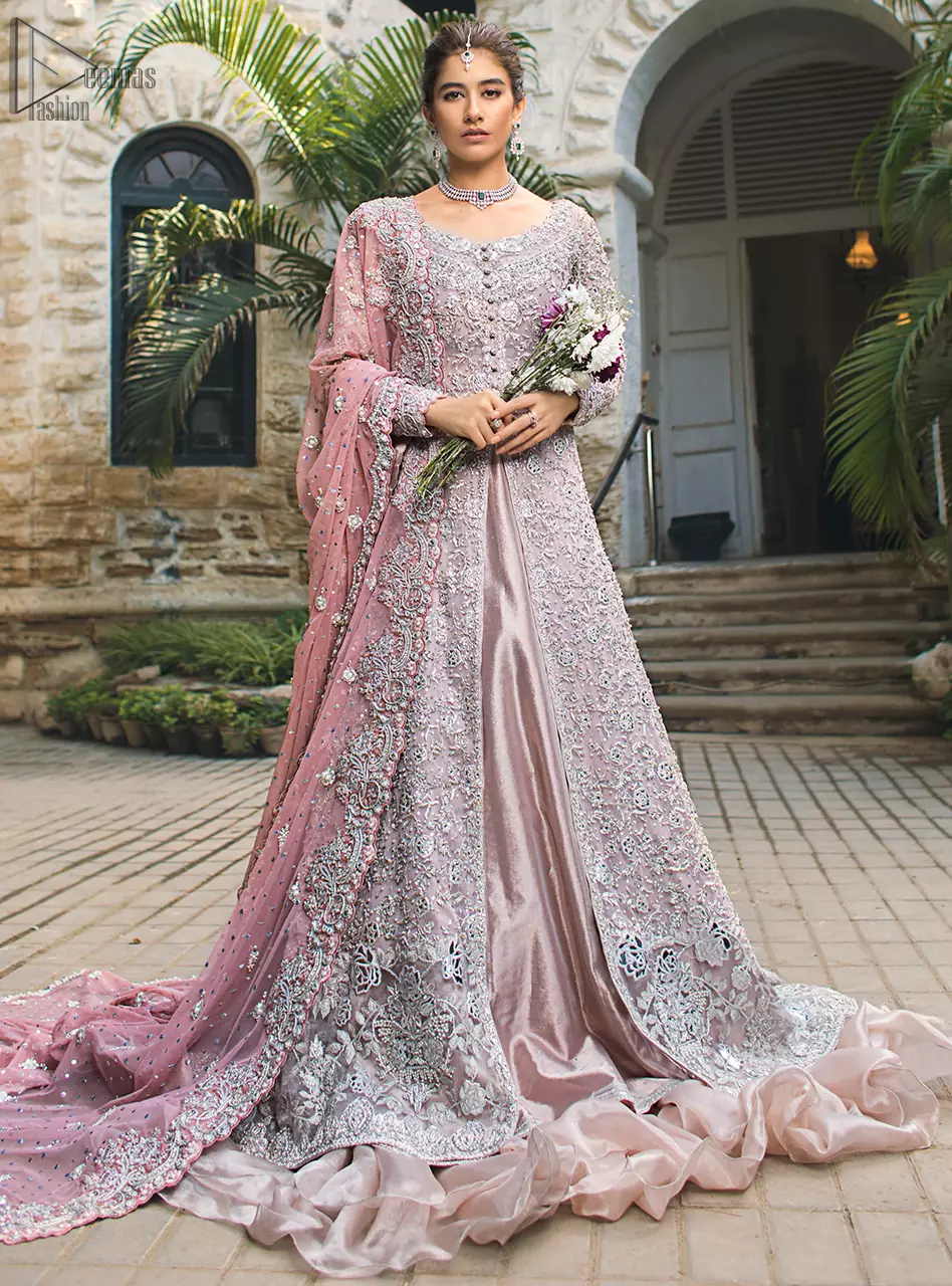 Intricate details, flamboyant silhouettes and mastery of colour are what makes this dress stand out from the rest. This is one of the elegant pieces that are sure to stay in your heart. Unique craftsmanship and detailed embellishments bring heavenly hued gossamer fabrics to life. The gown is beautifully sculptured with floral embroidery, adorned with intricately embellished borders with silver kora, Dabka, pearl and sequins work all over. Pair it up with a pink inner maxi and ruffled sharara gives the perfect ending to the outfit. The dupatta incorporates beautifully designed borders on all four sides, focusing on the heavily embellished pallu borders to give it a perfect maharani look.