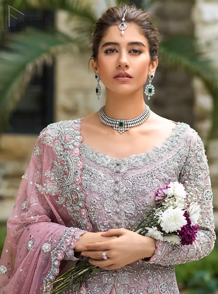 Intricate details, flamboyant silhouettes and mastery of colour are what makes this dress stand out from the rest. This is one of the elegant pieces that are sure to stay in your heart. Unique craftsmanship and detailed embellishments bring heavenly hued gossamer fabrics to life. The gown is beautifully sculptured with floral embroidery, adorned with intricately embellished borders with silver kora, Dabka, pearl and sequins work all over. Pair it up with a pink inner maxi and ruffled sharara gives the perfect ending to the outfit. The dupatta incorporates beautifully designed borders on all four sides, focusing on the heavily embellished pallu borders to give it a perfect maharani look.