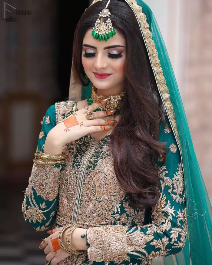 This breathtaking fit and flare wedding dress offers comfort without compromising on style. Featuring beautiful handwork, this outfit has a delicate arrangement of hand-embellished floral patterns with champagne zardozi work along the length. Refined craftsmanship is at its best with a hand embellished belt clenched elegantly at the waistline. It comes with a sea-green lehenga adorned with tiny motifs spray all over the ground and exaggerated with embroidered lace bottom. This outfit is paired up with an organza dupatta with embroidered border to give it a perfect ending.