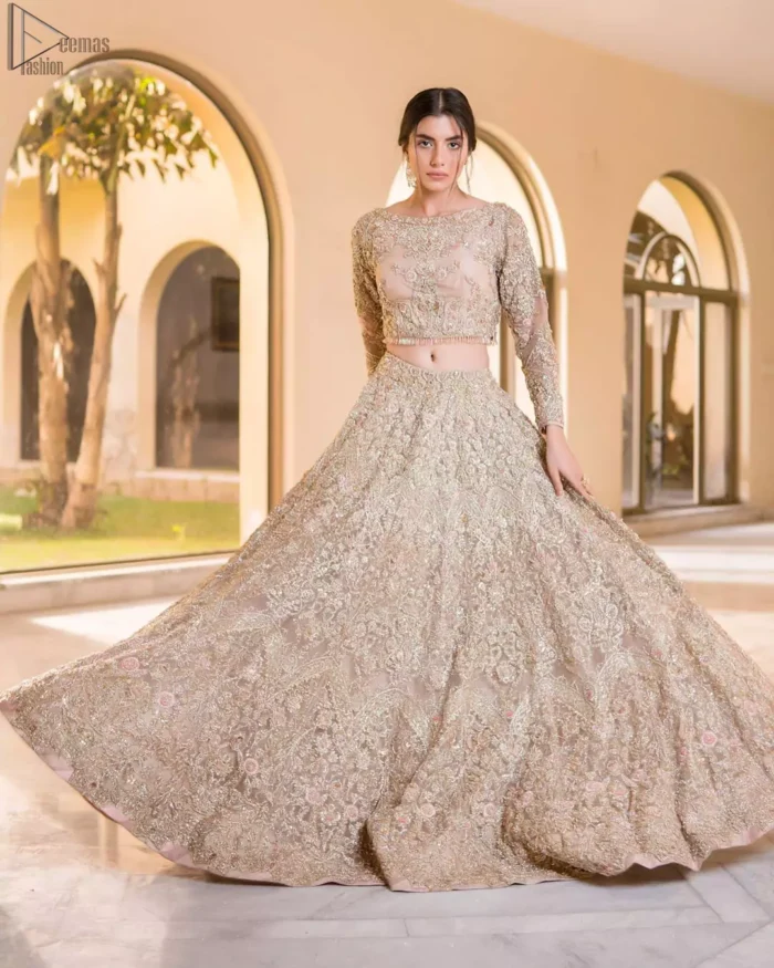 Picturing your bridal in a tea rose colour? This subtleness laden with ornamental embellishments and embroidery creates such a fairytale touch to your wedding. The boat-shaped blouse is emphasized with light golden zardozi work and finished with dangling pearls. Paired up with matching lehenga creates an unusual charisma wholeheartedly. Featuring beautiful handwork and a delicate arrangement of hand-embellished floral patterns with zardozi work along the length of lehenga. Refined craftsmanship is at its best with a hand embellished dupatta. The dupatta incorporates beautifully designed borders on all four sides, focusing on the heavily embellished pallu borders to give it a perfect maharani look.