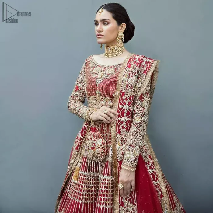 A bride wants to feel as beautiful as she is on her special day and knowing that our outfit was the final decision that, it is priceless. This handcrafted remarkable ensemble reflects the aura of the heavenly blouse and includes art deco design elements. The boat-shaped neckline of the blouse is beautifully handcrafted with zardozi work and vertical lines enhanced with beads on it. Complete the look with an artfully coordinated lehenga which is ornamented with a bold and captivating design with traditional intricate embroidery. Style it up with a red dupatta having four-sided embroidered borders and Kiran on it.