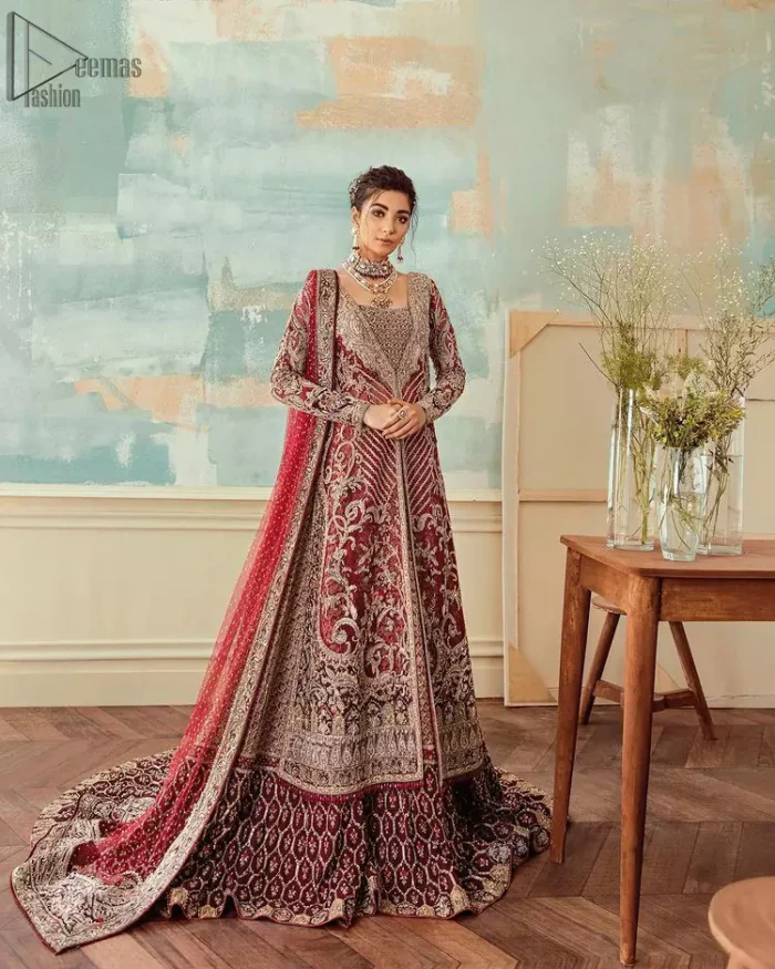 Chic, sleek and undeniably romantic, this beautiful deep red gown might just be the one for you. With pure fabric heavily laden with zardozi and the perfect blend of traditional flamboyance and modern elegance in design, you need to look no further for the perfect look for your special day. The bodice is heavily decorated with zardozi work, the rest of the gown is enriched with floral bootis and finished with the thick embellished bottom. Complete the look with an artfully coordinated lehenga which is ornamented with geometric patterns and captivating back trail design with traditional intricate embroidery. The outfit is coordinated with an organza dupatta finessed with embroidered borders.