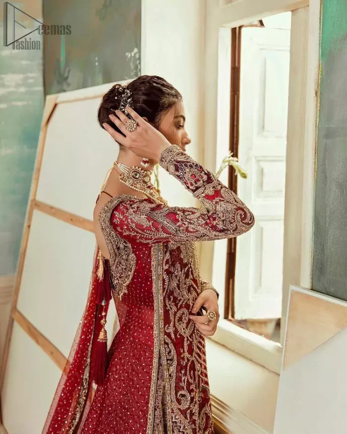 Chic, sleek and undeniably romantic, this beautiful deep red gown might just be the one for you. With pure fabric heavily laden with zardozi and the perfect blend of traditional flamboyance and modern elegance in design, you need to look no further for the perfect look for your special day. The bodice is heavily decorated with zardozi work, the rest of the gown is enriched with floral bootis and finished with the thick embellished bottom. Complete the look with an artfully coordinated lehenga which is ornamented with geometric patterns and captivating back trail design with traditional intricate embroidery. The outfit is coordinated with an organza dupatta finessed with embroidered borders.