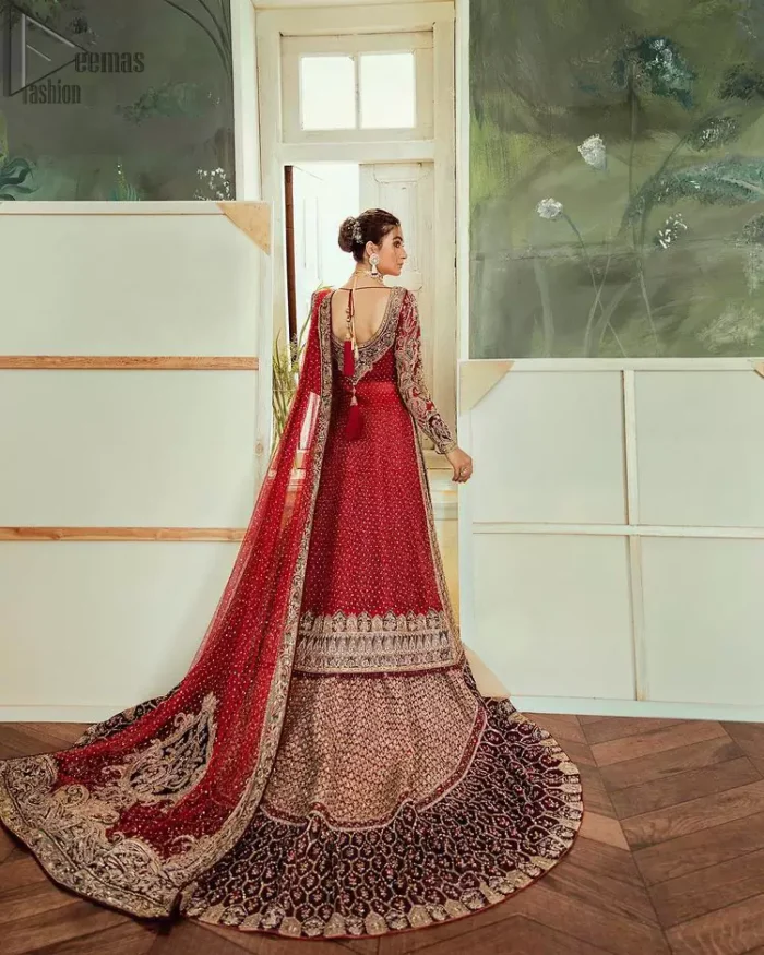 Chic, sleek and undeniably romantic, this beautiful deep red gown might just be the one for you. With pure fabric heavily laden with zardozi and the perfect blend of traditional flamboyance and modern elegance in design, you need to look no further for the perfect look for your special day. The bodice is heavily decorated with zardozi work, the rest of the gown is enriched with floral bootis and finished with the thick embellished bottom. Complete the look with an artfully coordinated lehenga which is ornamented with geometric patterns and captivating back trail design with traditional intricate embroidery. The outfit is coordinated with an organza dupatta finessed with embroidered borders.