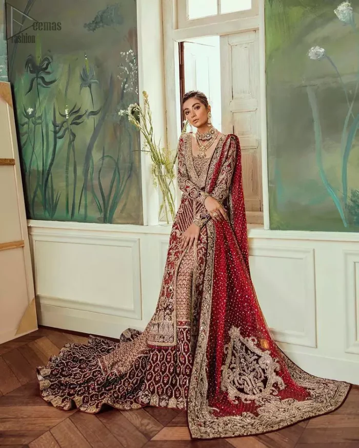 Chic, sleek and undeniably romantic, this beautiful deep red gown might just be the one for you. With pure fabric heavily laden with zardozi and the perfect blend of traditional flamboyance and modern elegance in design, you need to look no further for the perfect look for your special day. The bodice is heavily decorated with zardozi work, the rest of the gown is enriched with floral bootis and finished with the thick embellished bottom. Complete the look with an artfully coordinated lehenga which is ornamented with geometric patterns and captivating back trail design with traditional intricate embroidery. The outfit is coordinated with an organza dupatta finessed with embroidered borders.