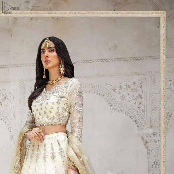 Designed with great expertise, the Ivory Blouse Lehenga is going to set you on a heavenly journey, full of comfort, merriment and unlimited beauty. In a professional sense of full sleeves, the dress is laudable for its majestic light golden and silver embroidery under the very meritorious round neckline. To contribute towards its eminence, this bridal wear is made with the finest organza. A lehenga and an exquisite net dupatta make this marvelous attire a paragon of extreme beauty on your Walima.